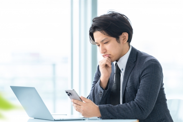 お悔やみの言葉をメールで送る男性