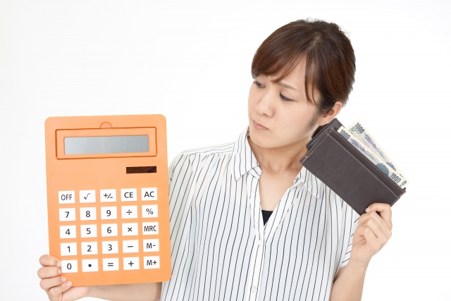 財布を持ちながら電卓を見る女性