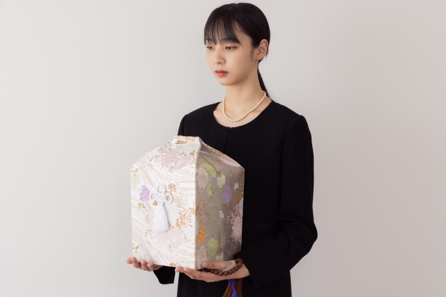 遺骨を持つ女性