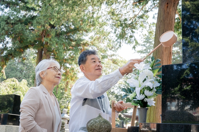 お墓参りをする夫婦