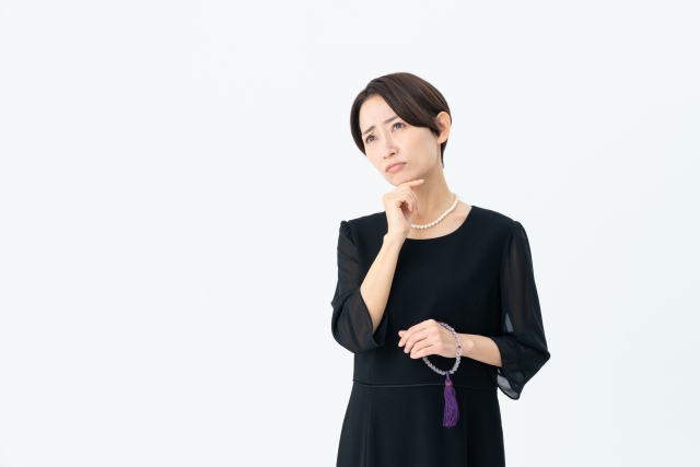 悩む喪服の女性