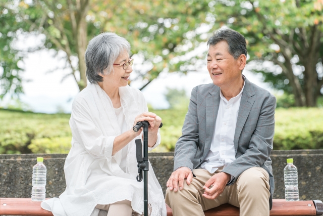 公園で話すシニア夫婦