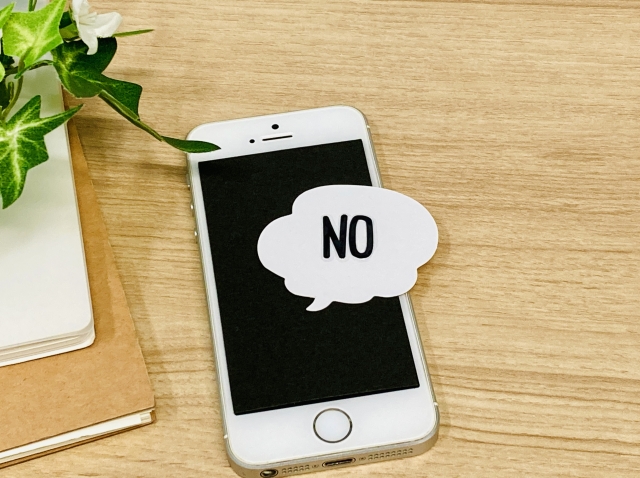 「NO」の文字とスマホ