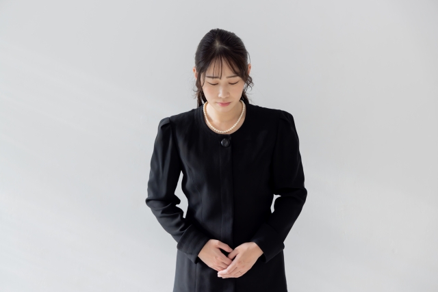 おじぎをする喪服の女性