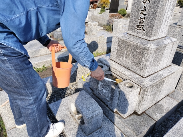 お墓を掃除する男性